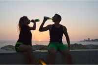 Eine Paar entspannt im Sonnenuntergang mit einer Bierflasche, am Timmendorfer Strand